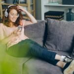 a woman sitting on a couch listening to music